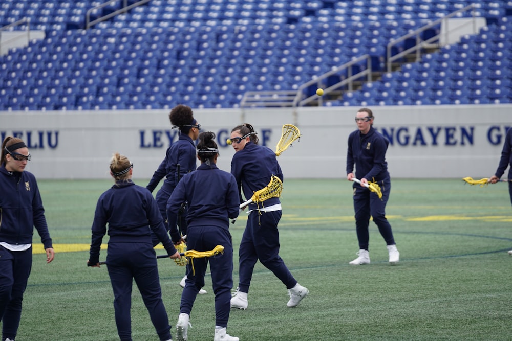 women playing lacrosse on field during daytime