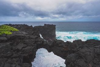 Picture of a rugged volcanic rock coastline contrasting with blue sea waves