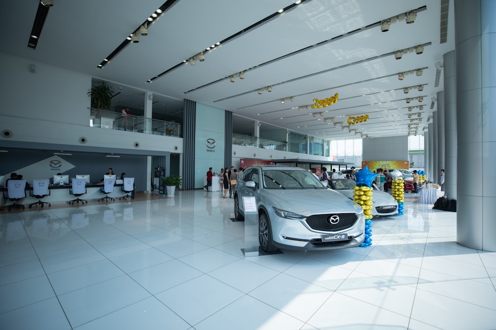 people inside building and different vehicles on display