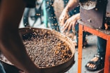 a group of people standing around a bowl of food