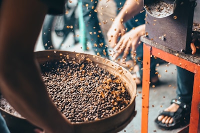 a group of people standing around a bowl of food