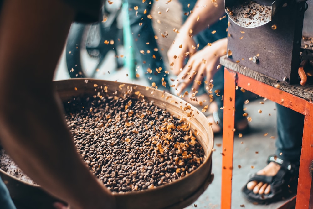 a group of people standing around a bowl of food