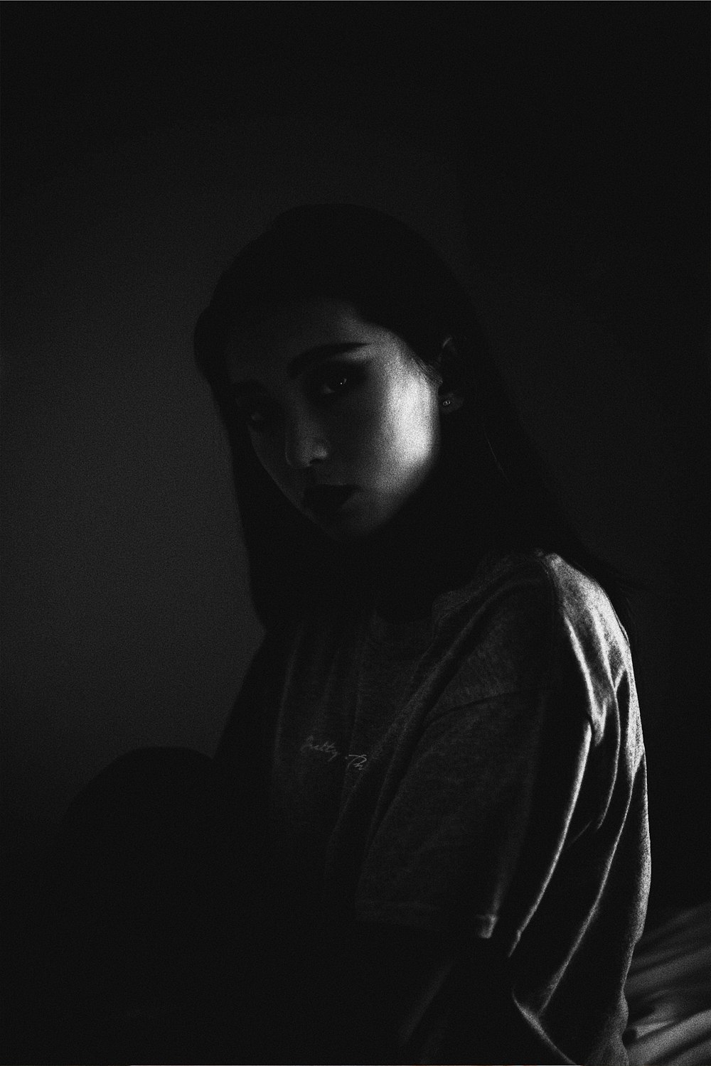 어두운 방 안에 있는 여자의 회색조 사진