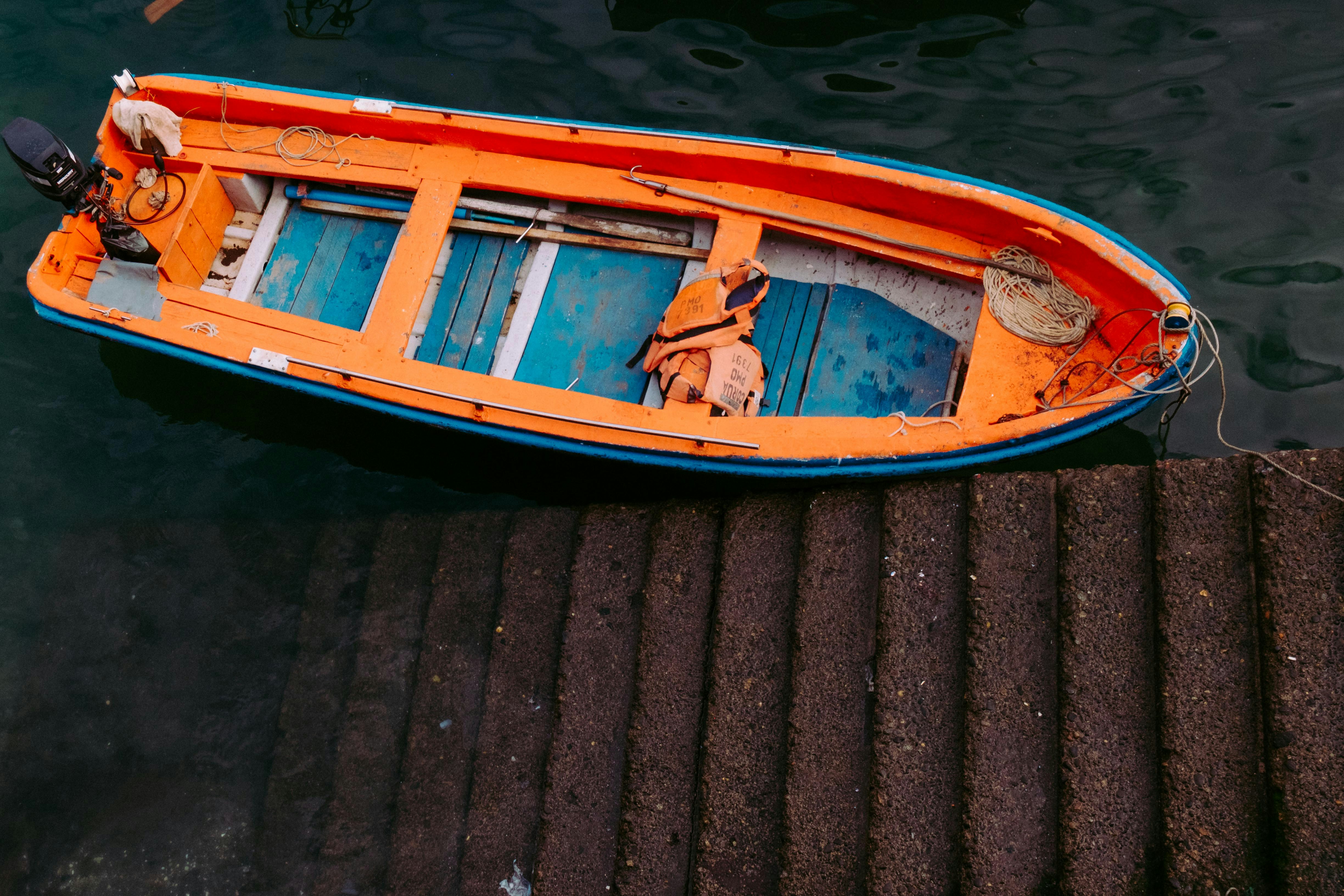 Yellow, red, and blue boat beside concrete stair photo – Free Boat