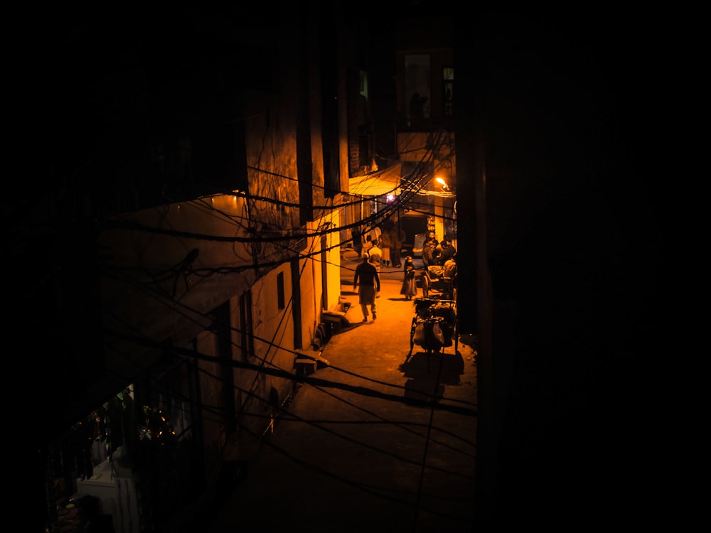 a group of people walking down a street at night