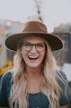 selective focus photography of smiling woman wearing brown hat