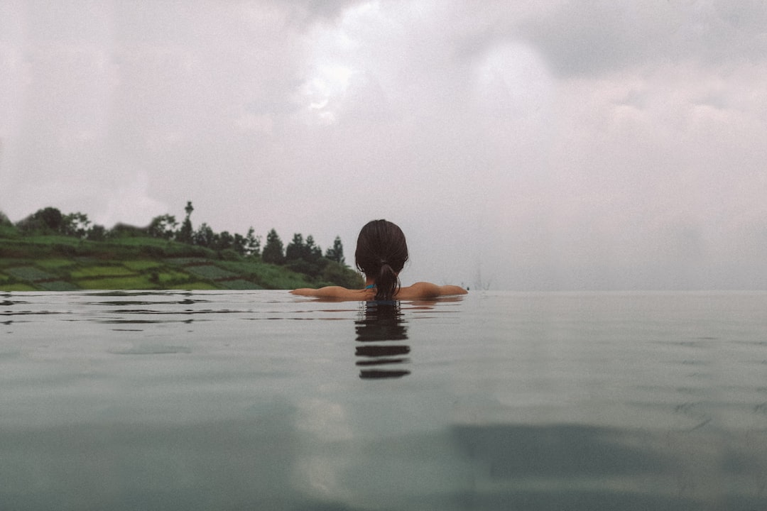 woman swimming on calm body of water
