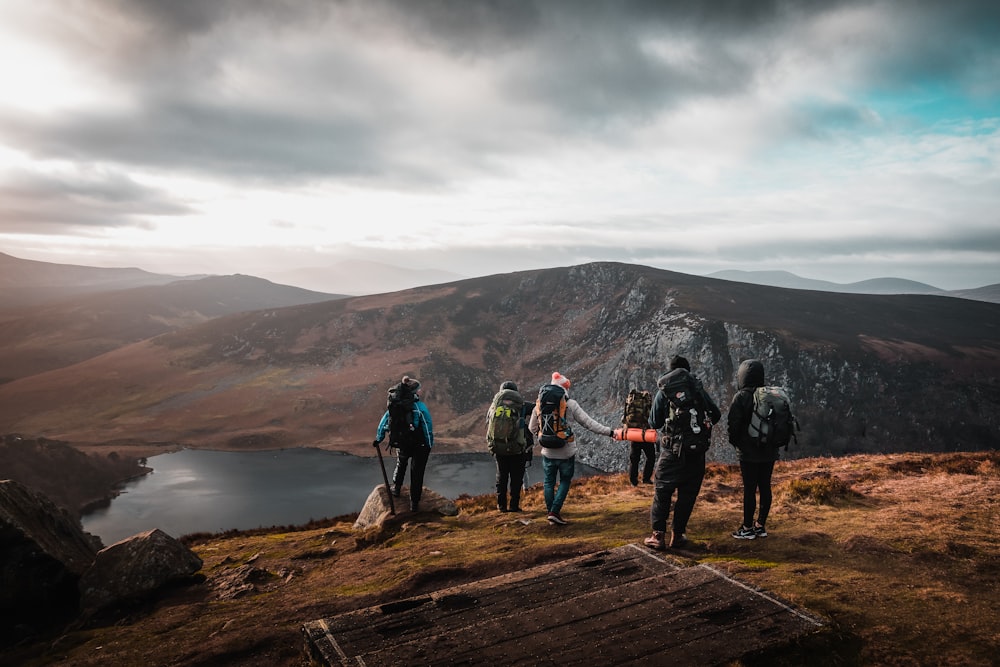 group of people on top of mountain under gray sky