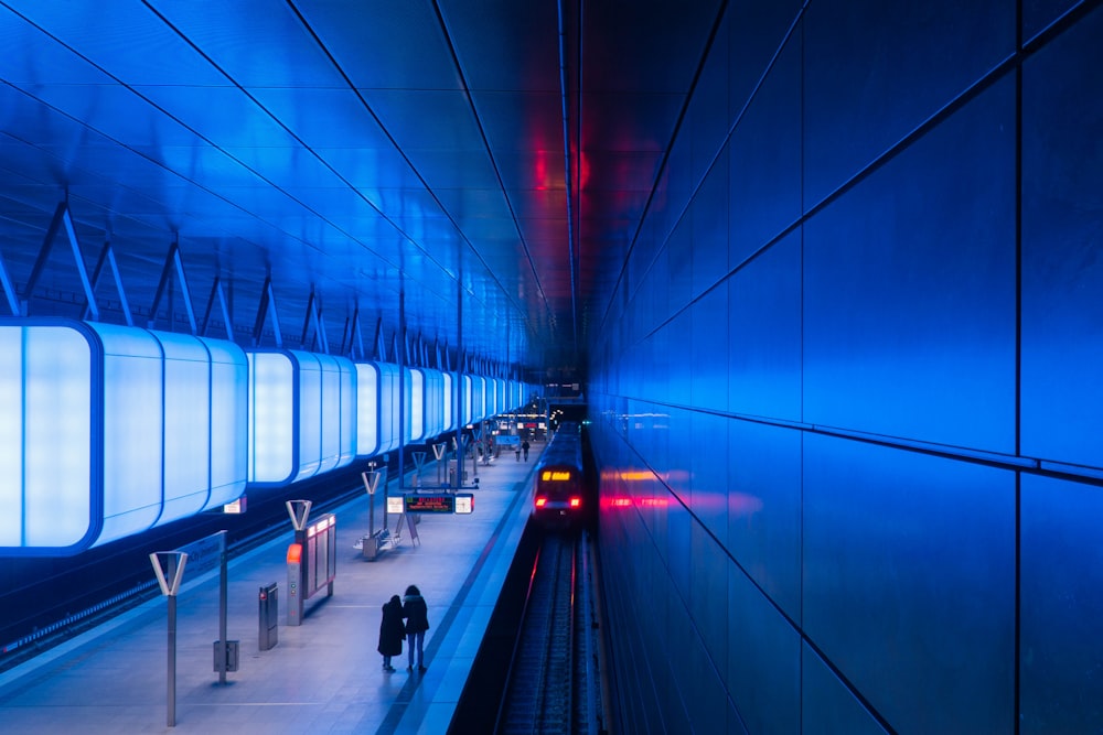 a subway station with people walking on the platform