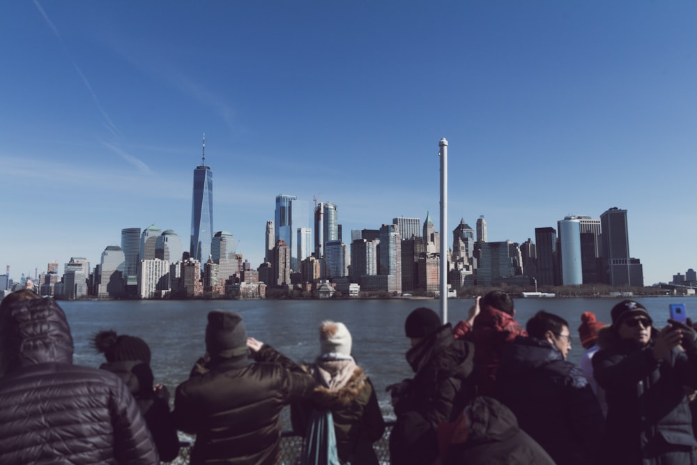 people taking picture of city skyline during clear blue sky