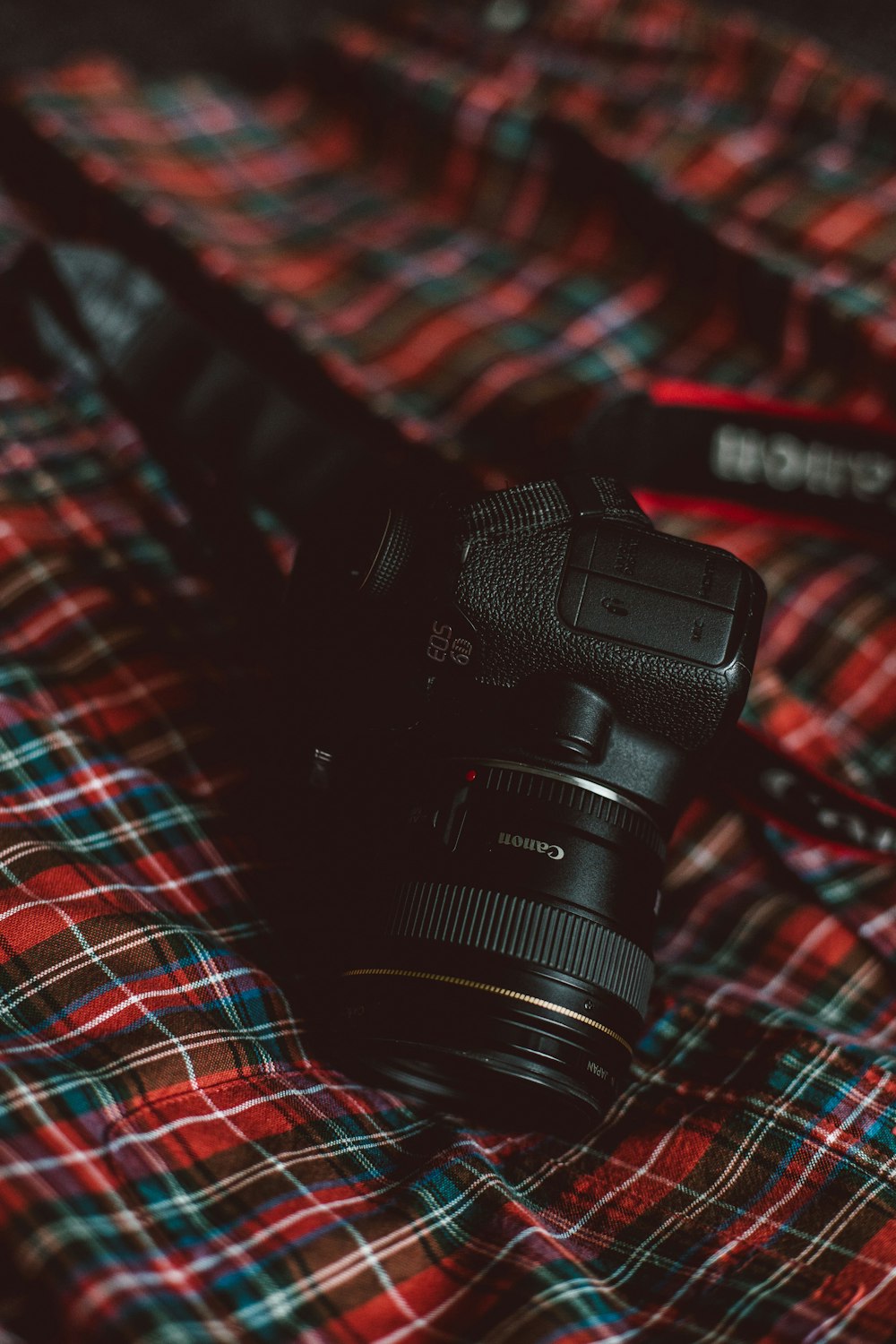 black Canon camera on plaid textile