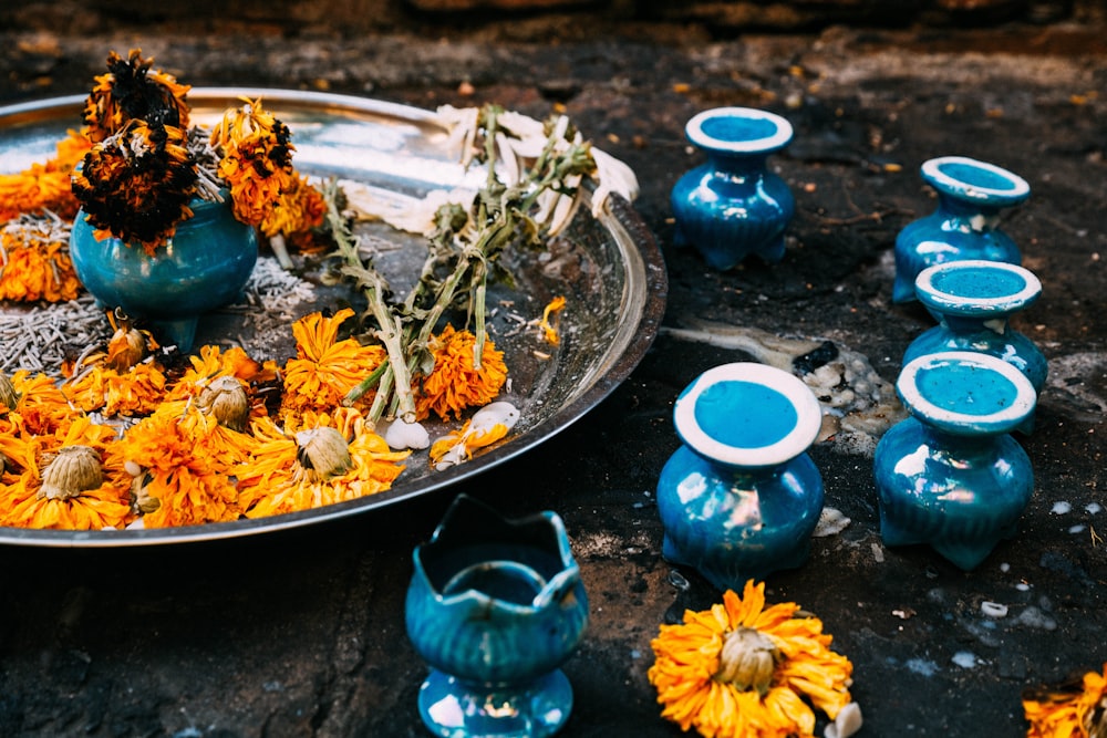 a platter filled with yellow flowers next to blue vases