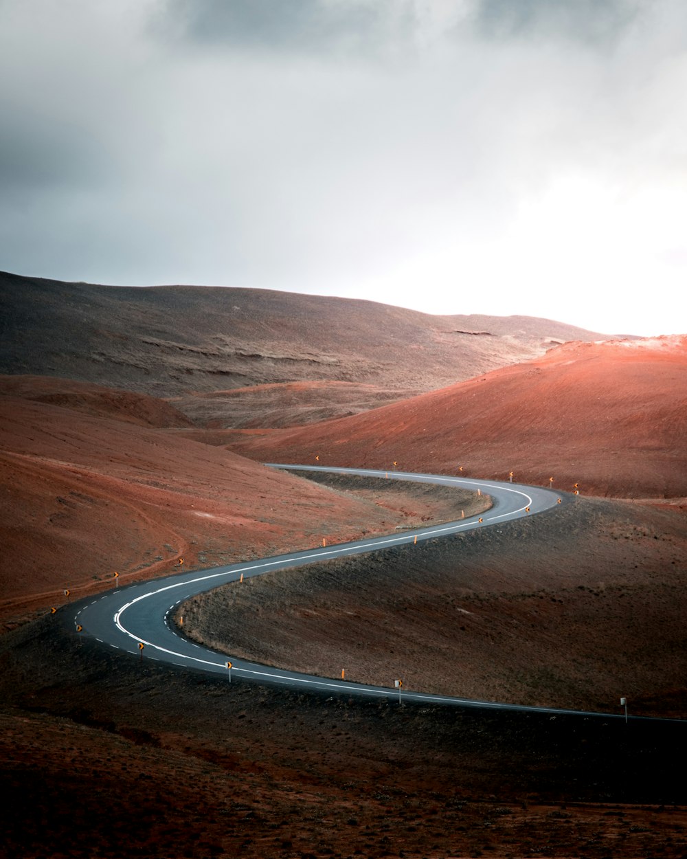 empty road in middle of hills during daytime