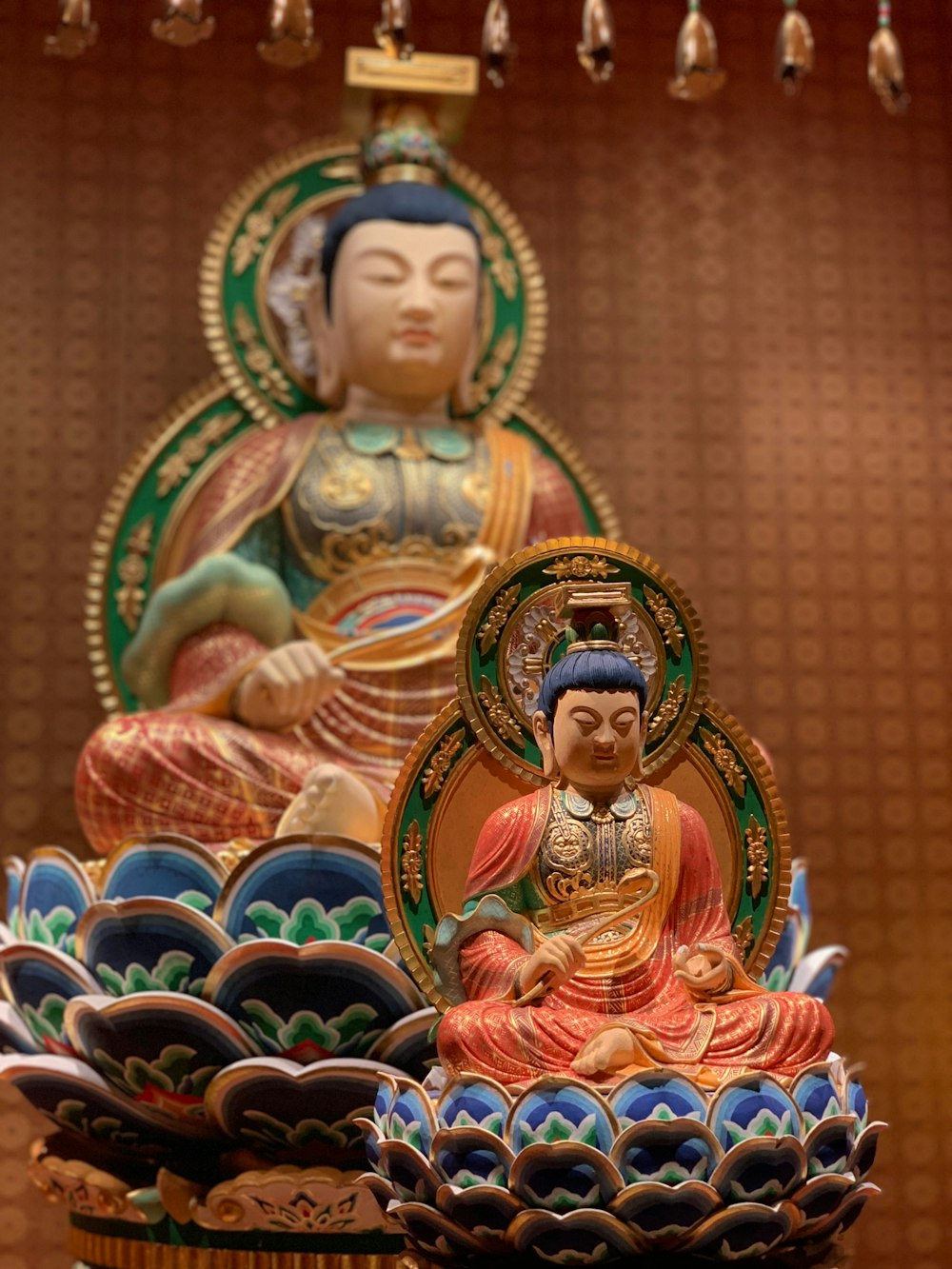 low-angle photography of Buddha sitting on lotus statues