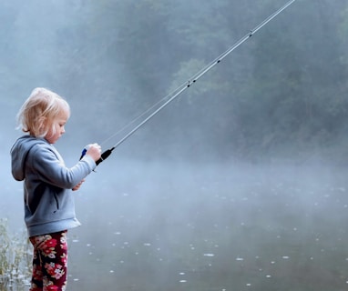 toddler wearing gray hoodie holding fishing rod