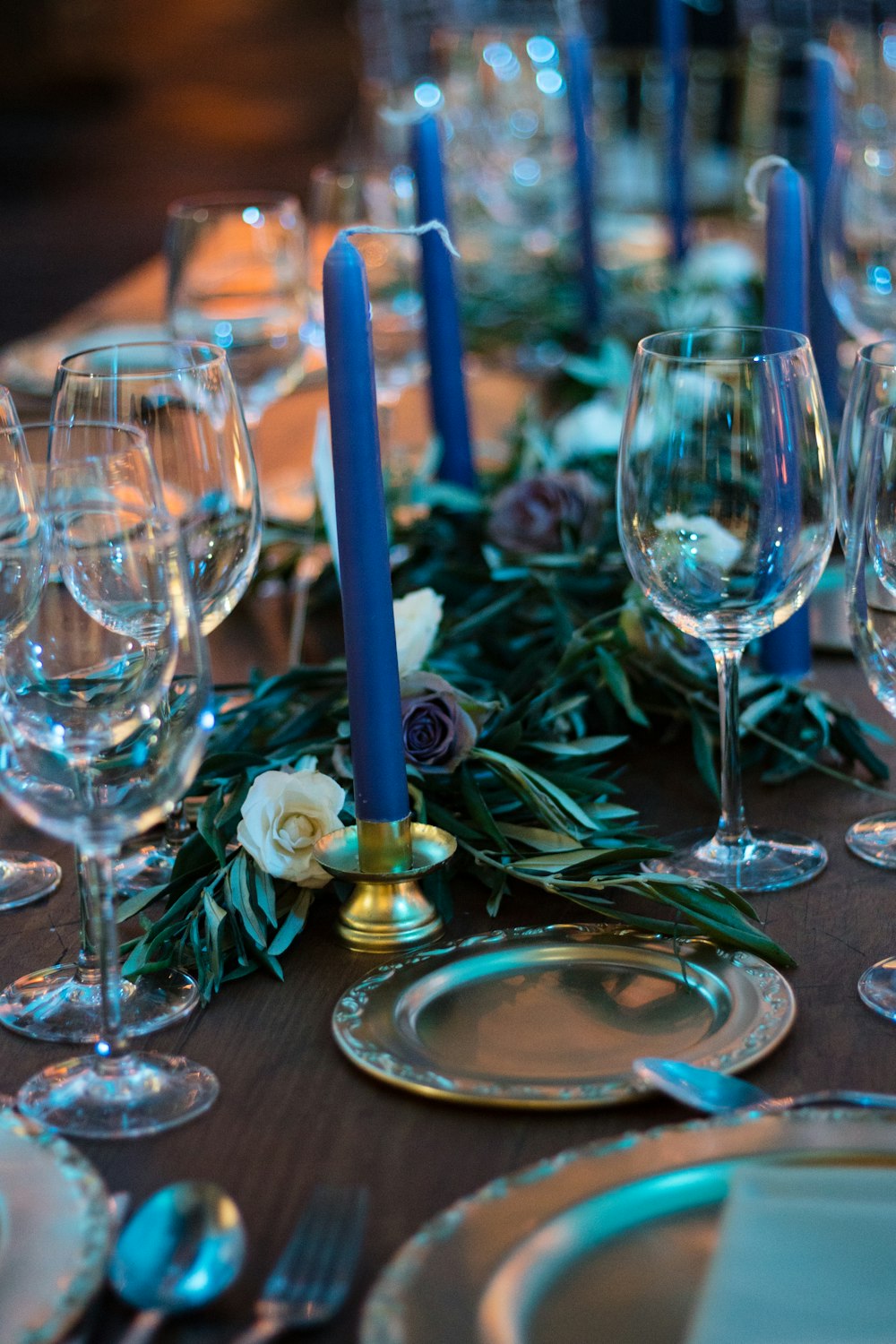 clear wine glasses and blue taper candles