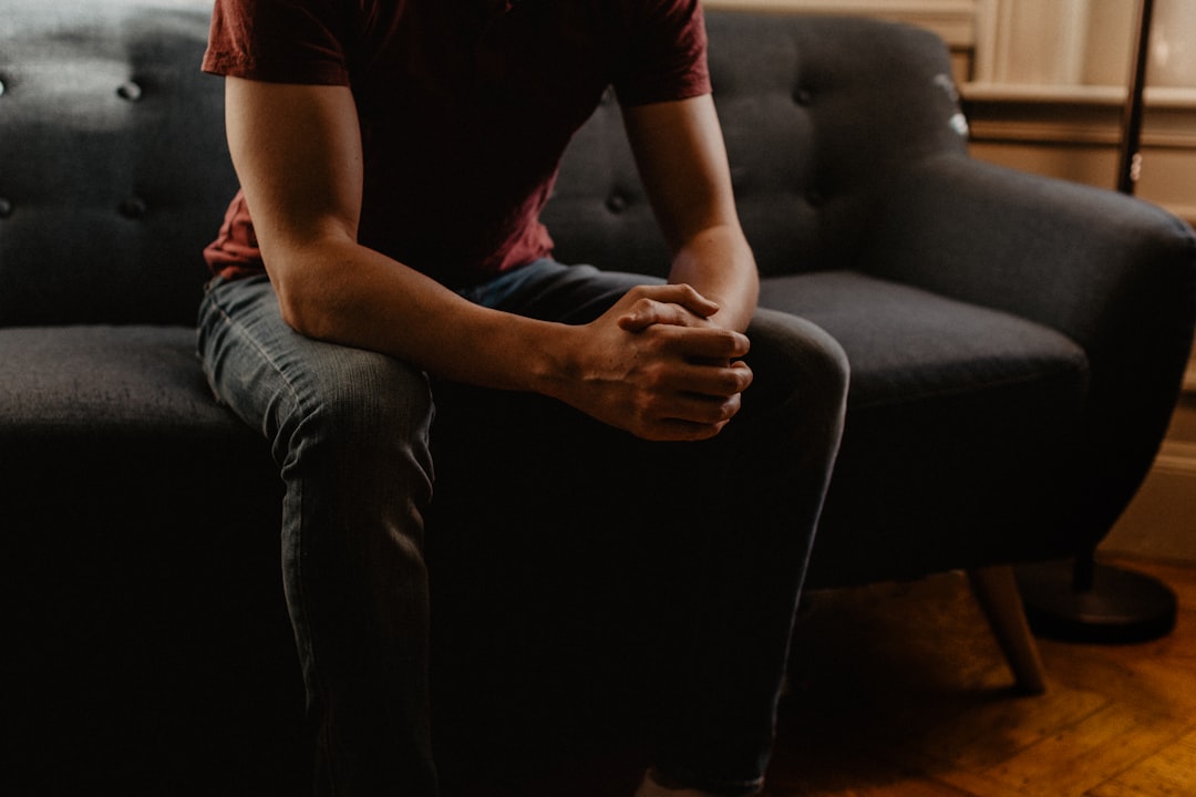 sitting on sofa with hands clasped