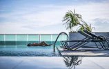 woman lying at pool beside fence during daytime