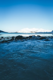 A serene landscape featuring icy mountains and a clear sky.