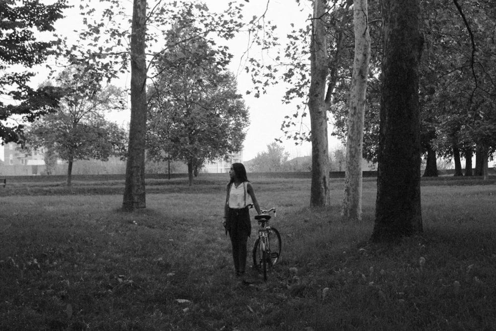 grayscale photography of woman holding bike