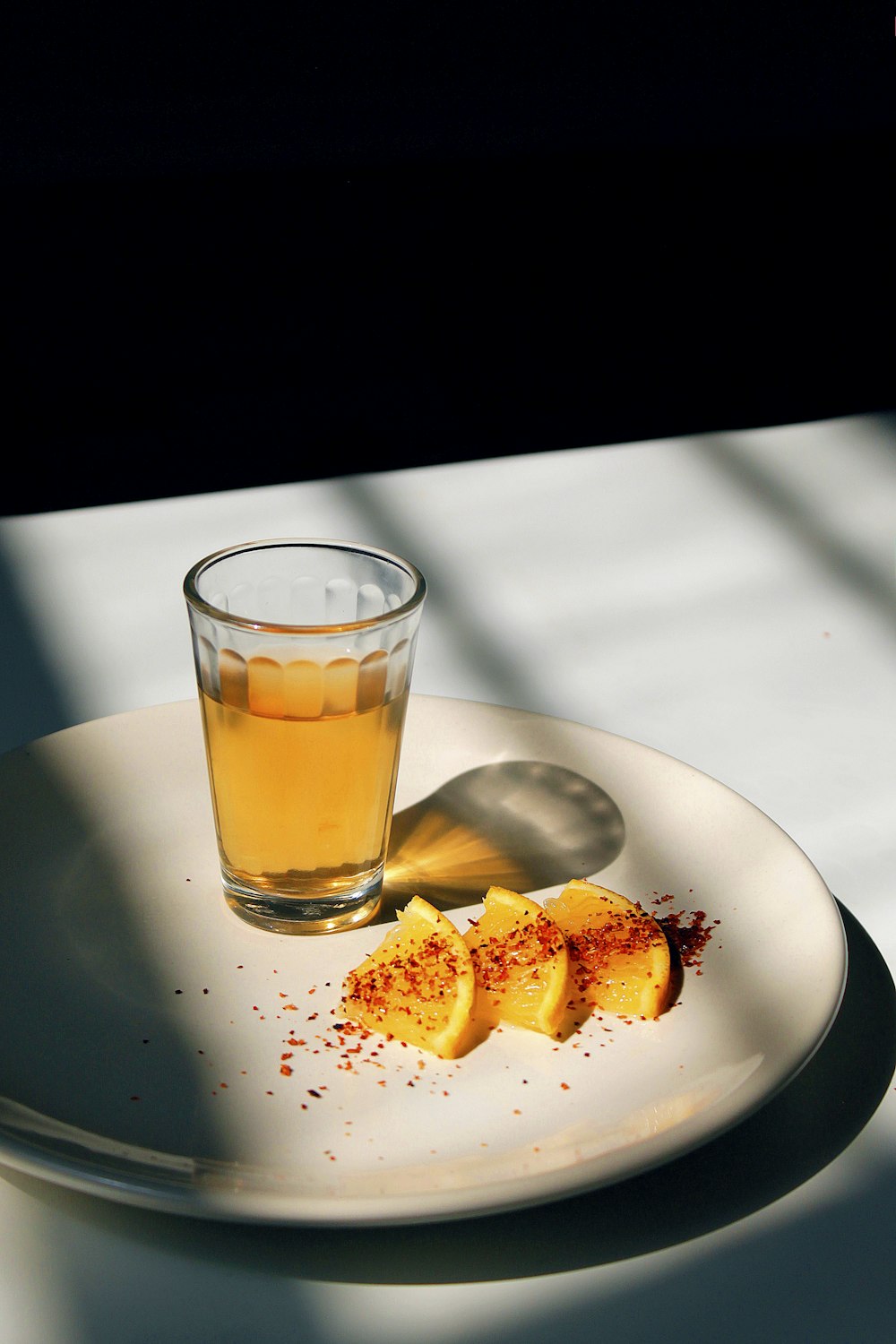 Plato redondo de cerámica blanca con rodajas de naranja