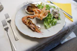 Elegant plated dish featuring fresh Atlantic seafood with golden accents on a dark wooden table.