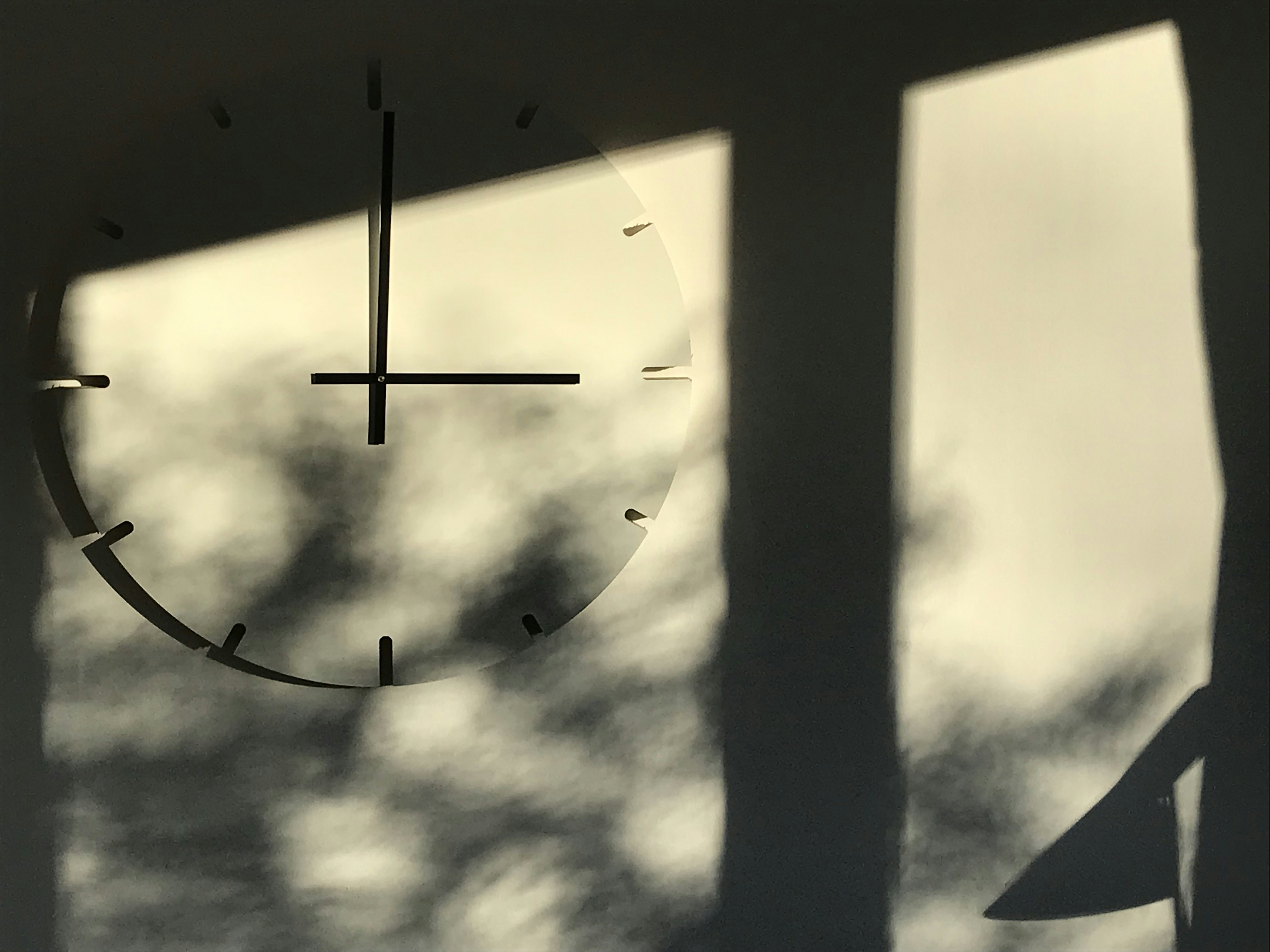 An old broken wall clock with light passing through cracks, surreal and thoughtful mood