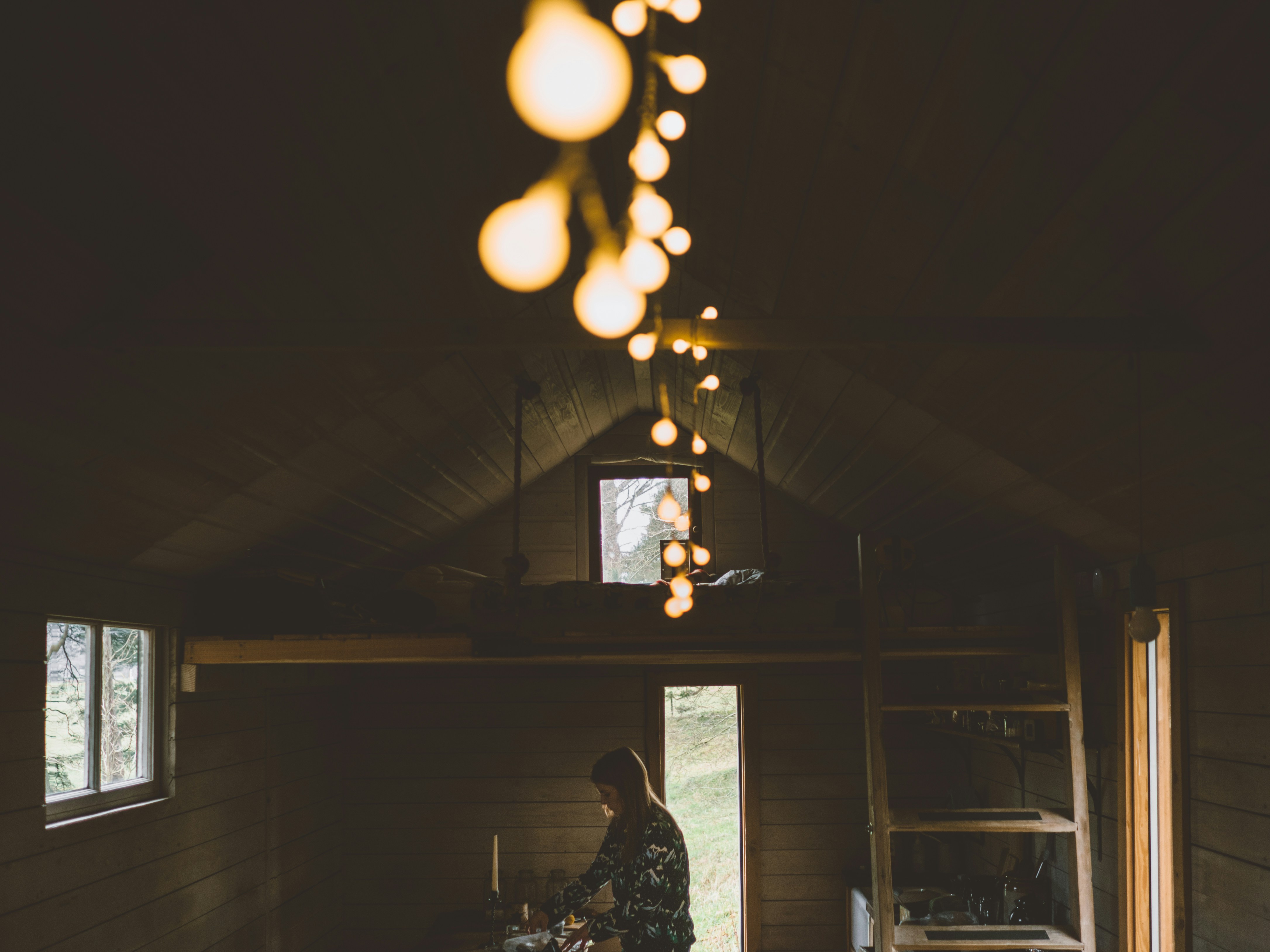 woman standing inside brown wooden house, 