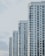 A series of modern high-rise apartment buildings with numerous windows and balconies, positioned side by side in a slightly staggered formation. The buildings appear to be well-maintained and have a uniform architectural style with a clean, minimalistic design.