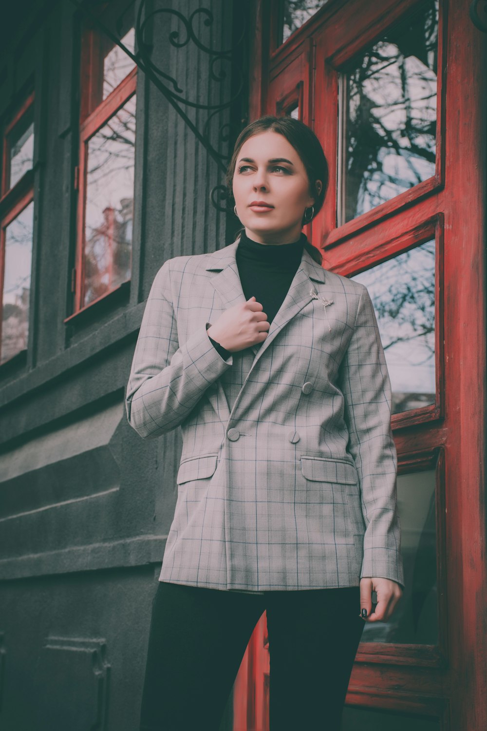 woman sitting next to red door