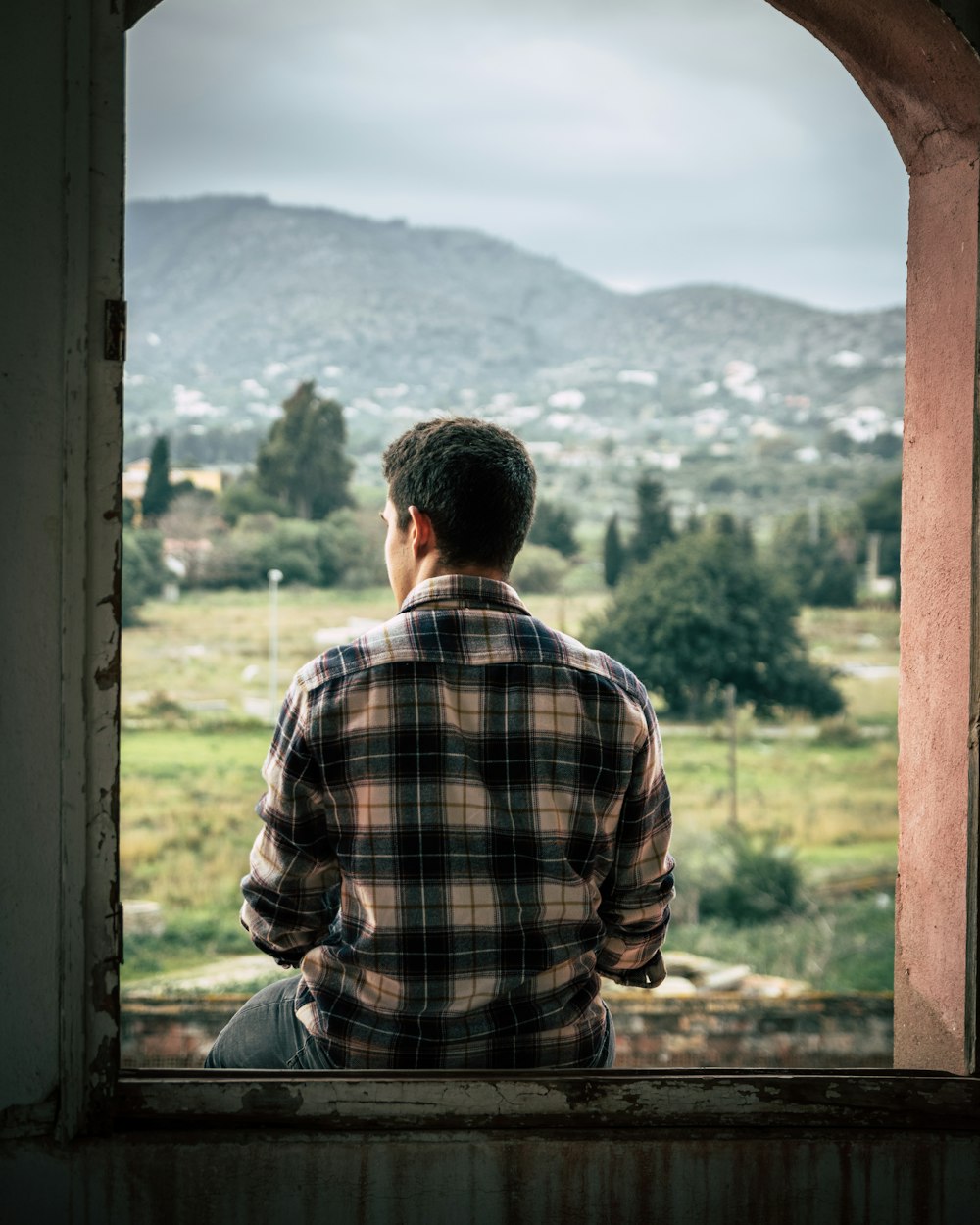 man sitting on window