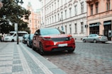 red range rover parked near building during daytime