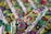 An intricate textile with vibrant embroidery featuring circular and spiral patterns in various colors. The fabric displays a complex design with layers of green, red, purple, and blue threads against a textured background.