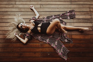 smiling woman lying on brown wooden surface