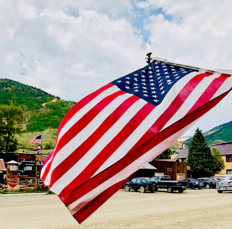 American flag waving over a small-town redemption center on a bright sunny day.