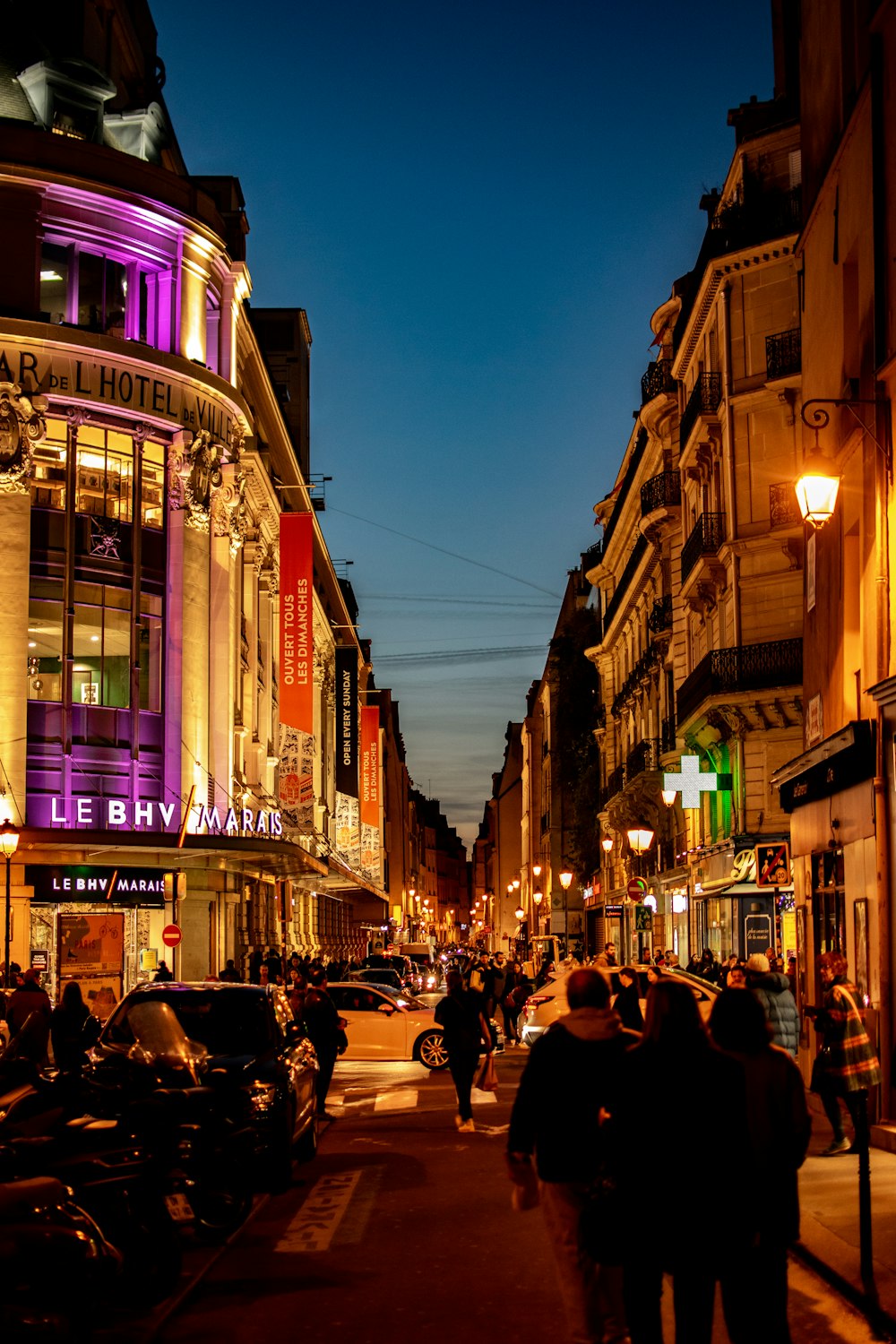 people walking on street beside building during night time