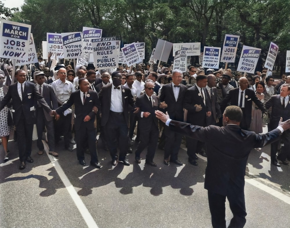 Hombres de traje caminando por la calle sosteniendo carteles