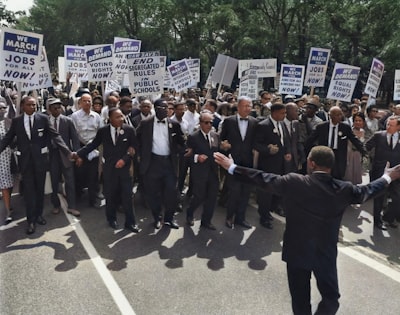 men in suit walking on street holding signages civil right teams background