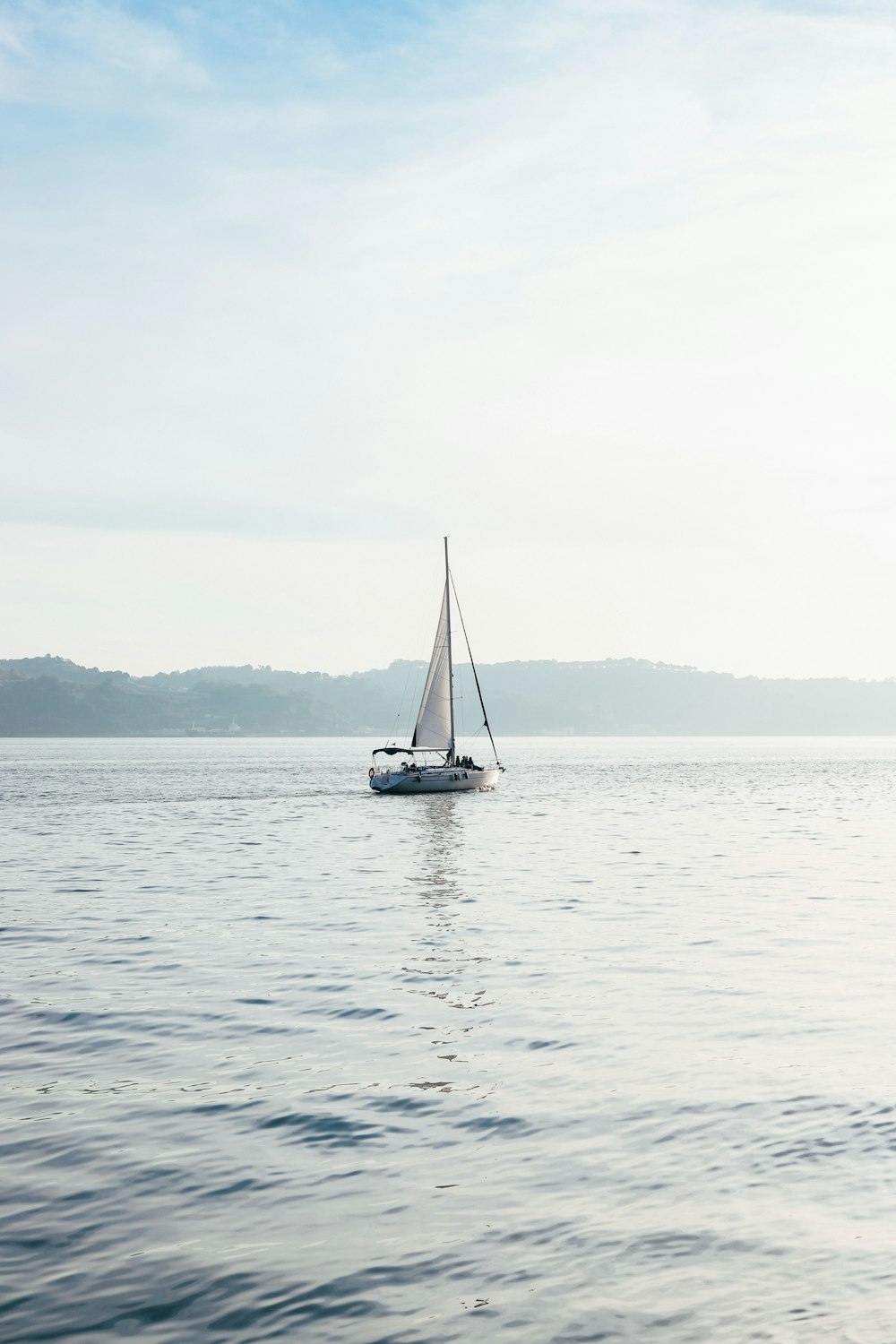 velero blanco en el cuerpo de agua durante el día