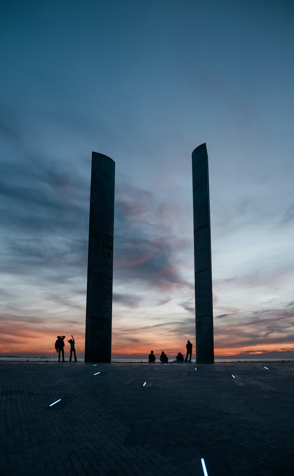 silhouette photography of people beside tower during golden hour