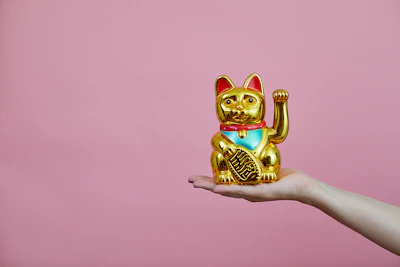 Close-up of a golden Maneki-neko cat ornament shimmering under soft light