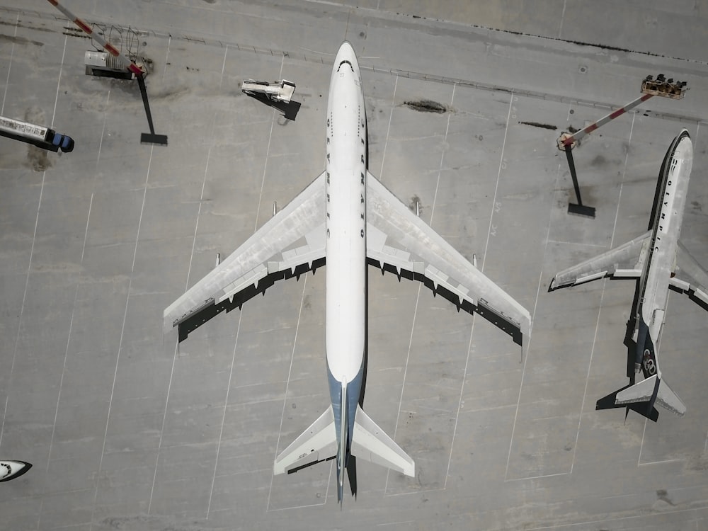 white airplane parked beside another airplane
