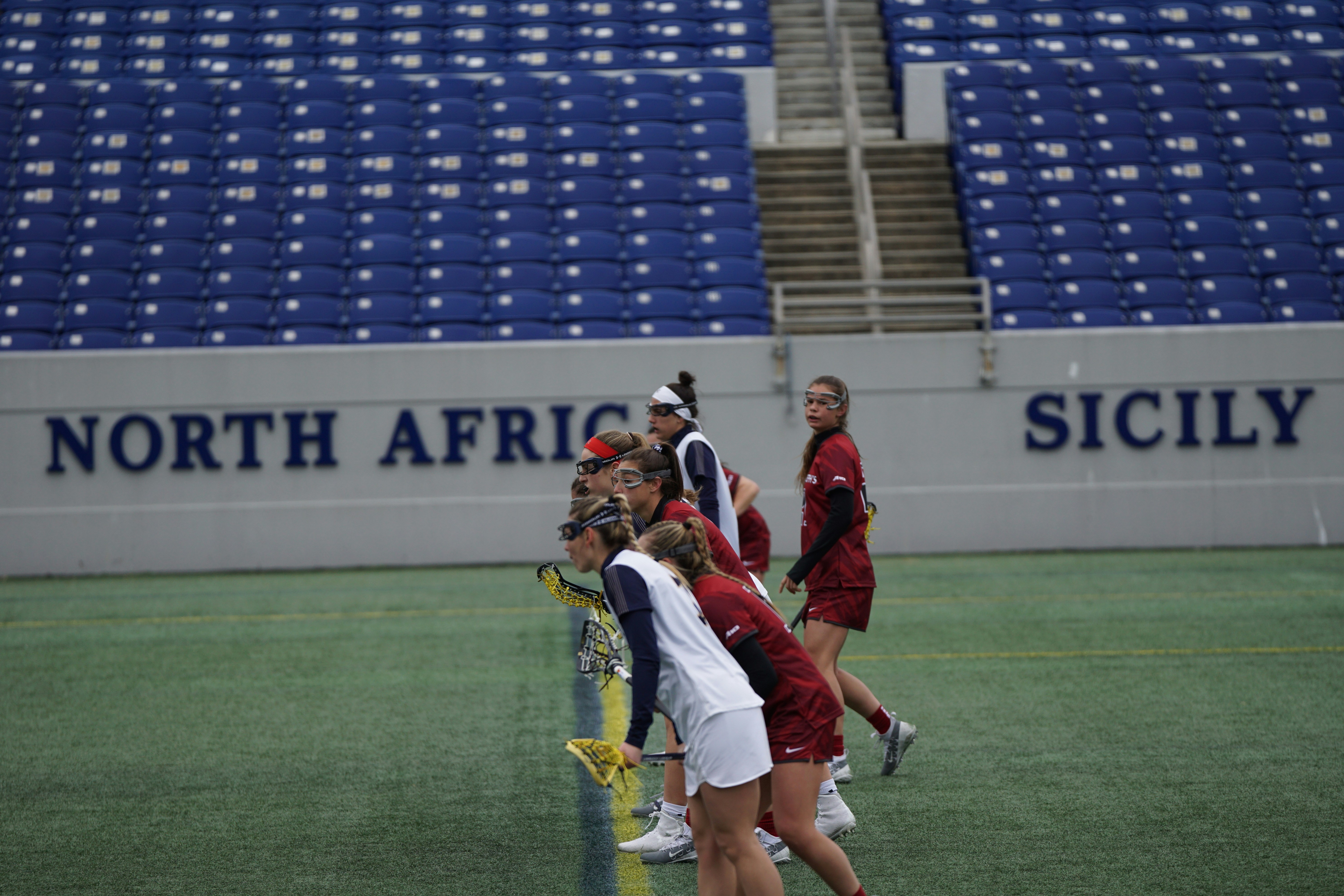 wanita bermain lacrosse di lapangan
