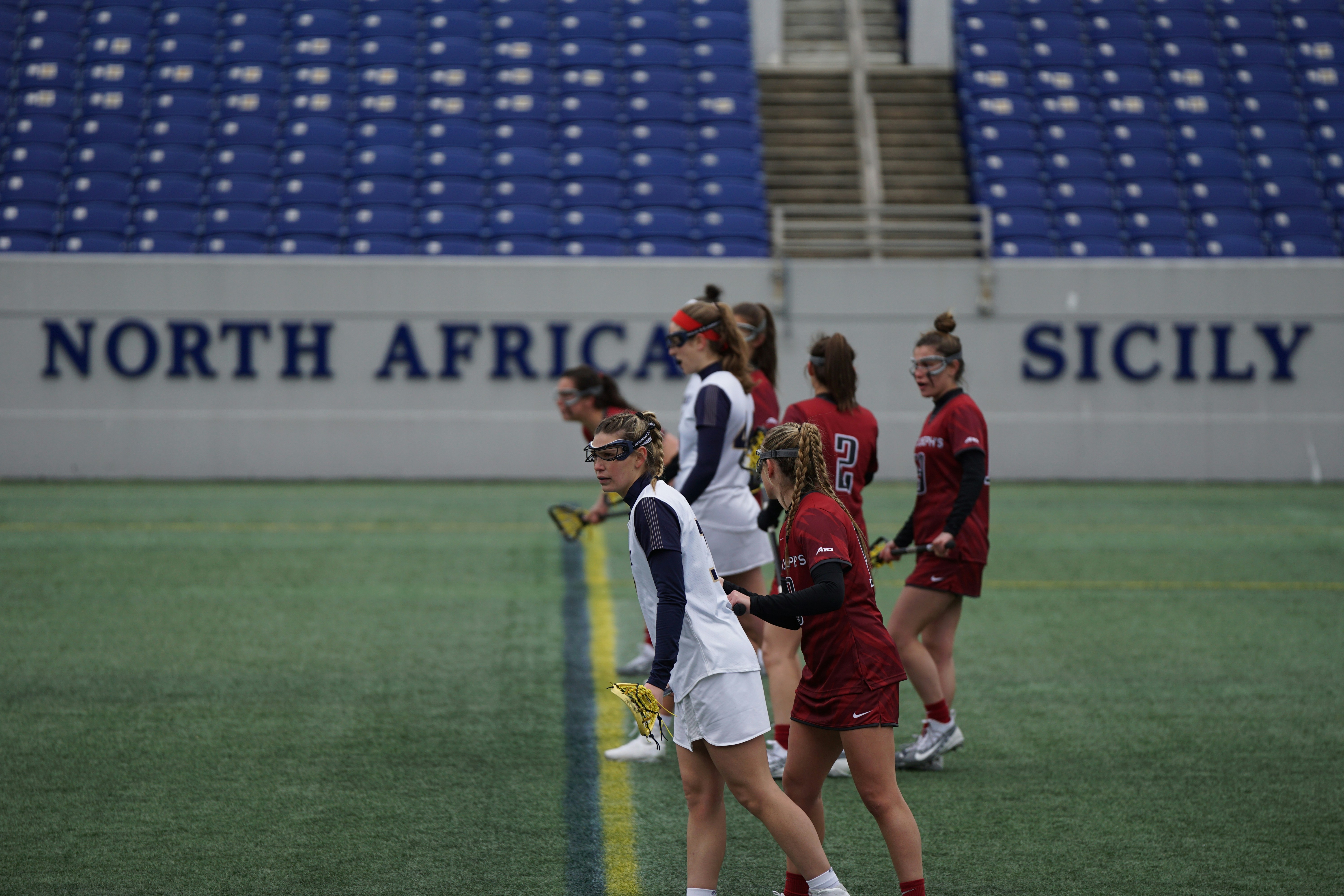 women playing lacrosse on field