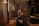 Elegant man enjoying a sophisticated evening in a luxurious private setting with warm golden lighting.