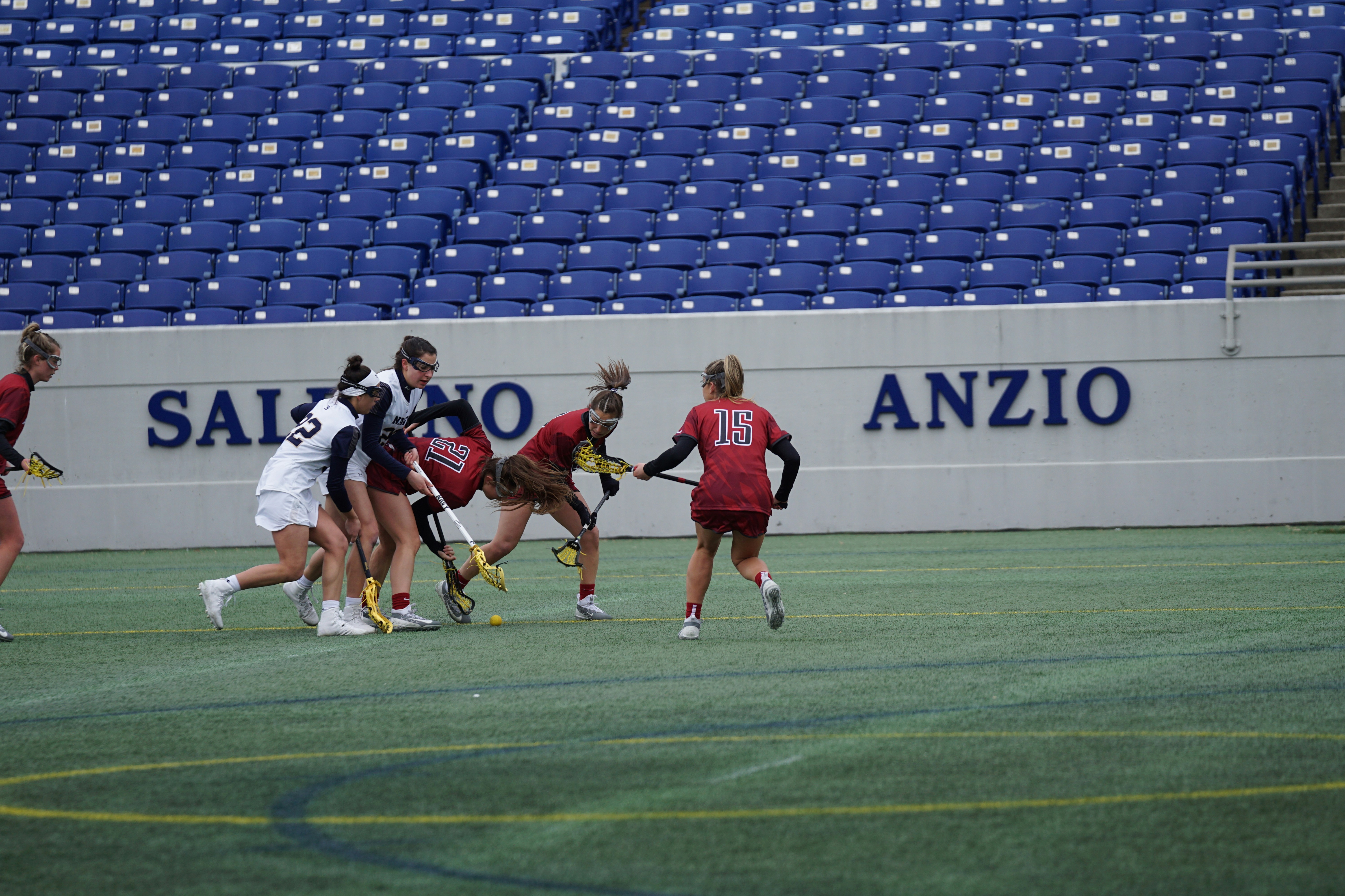 wanita bermain lacrosse di lapangan