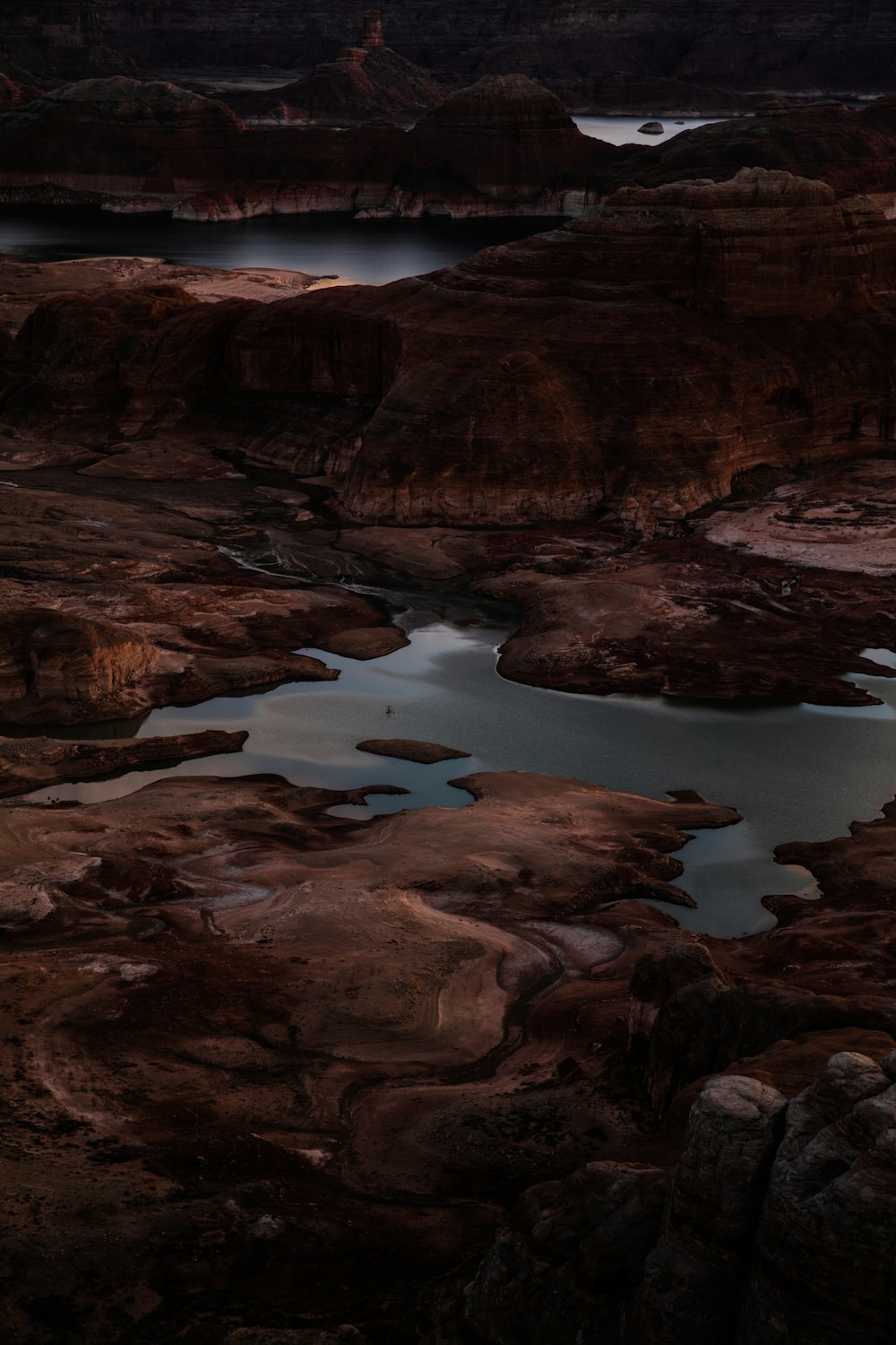 calm body of water near brown rocks