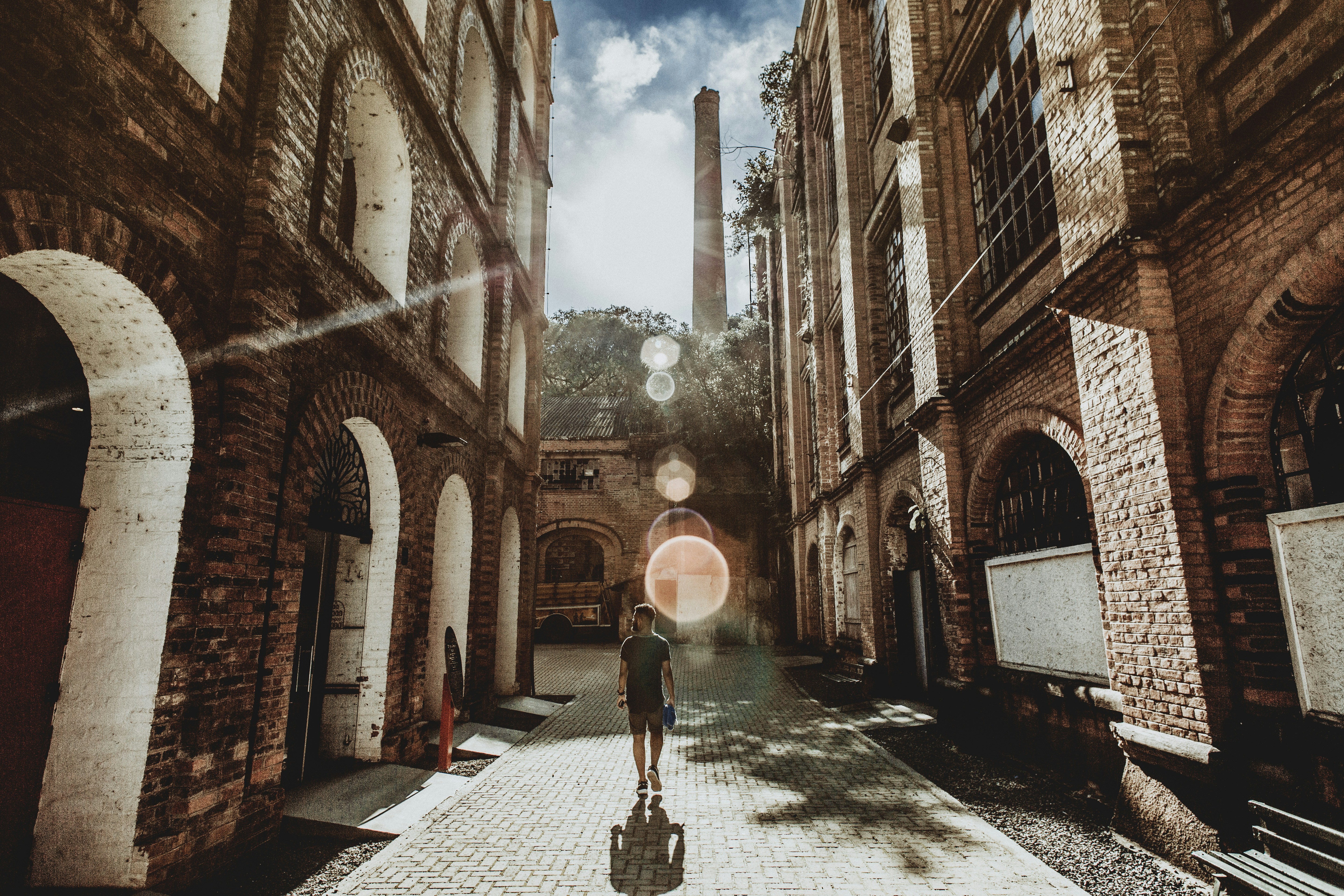 Город времени фото man walking in between bricked building at daytime photo - Free Human Image on U