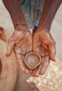 Smiling kids proudly holding up their hand-painted pottery.
