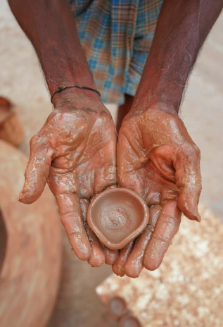 A joyful group photo of students holding their handmade pottery creations.